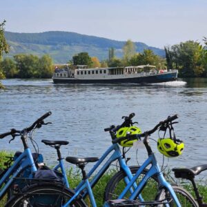 Bike standing on the shore while the Iris barge sails by on the Moselle