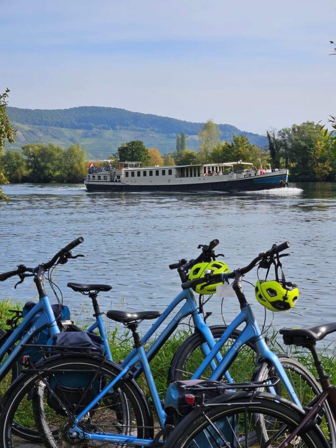 Bike standing on the shore while the Iris barge sails by on the Moselle